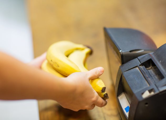 close up of hands buying bananas at checkout groceries market food cashier