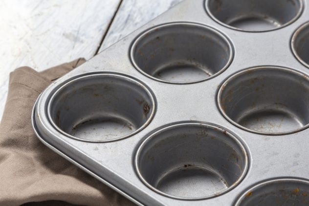 Muffin tray on wooden table baking