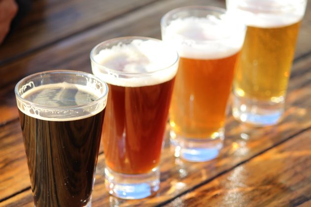 A selection of four craft beers during a tasting session on a wooden table